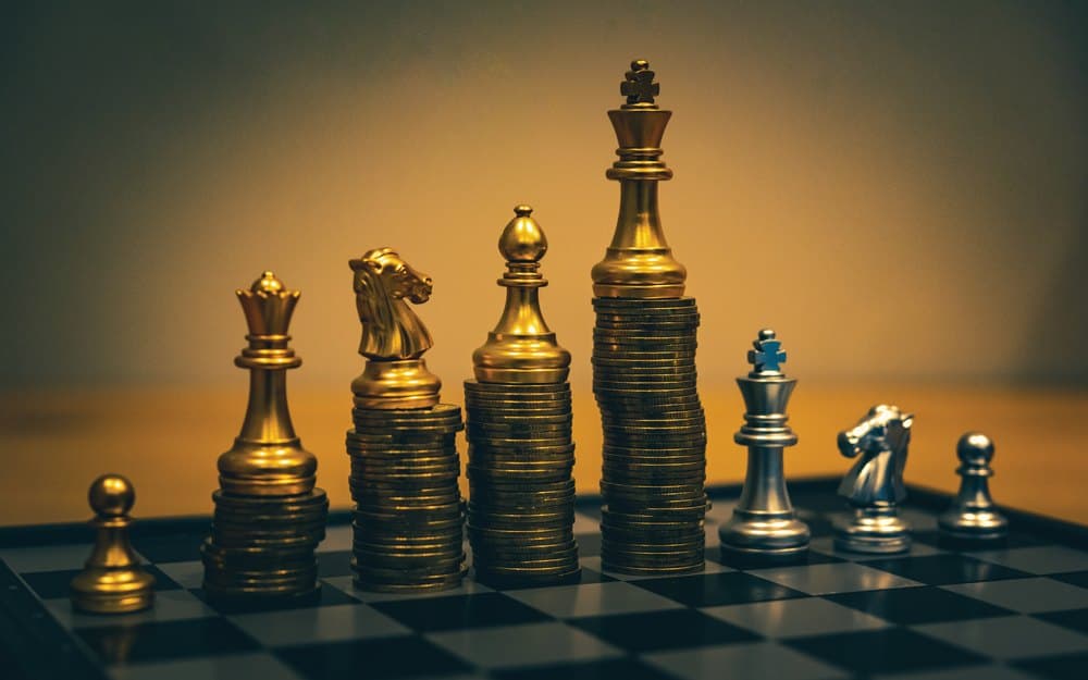 Chess pieces standing on stacks of coins, from ALOT Wealth Management's 2024 material
